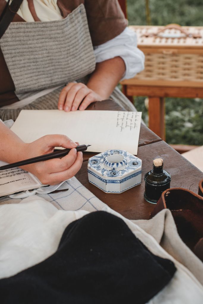 Eine Hand schreibt mit Tinte auf Papier