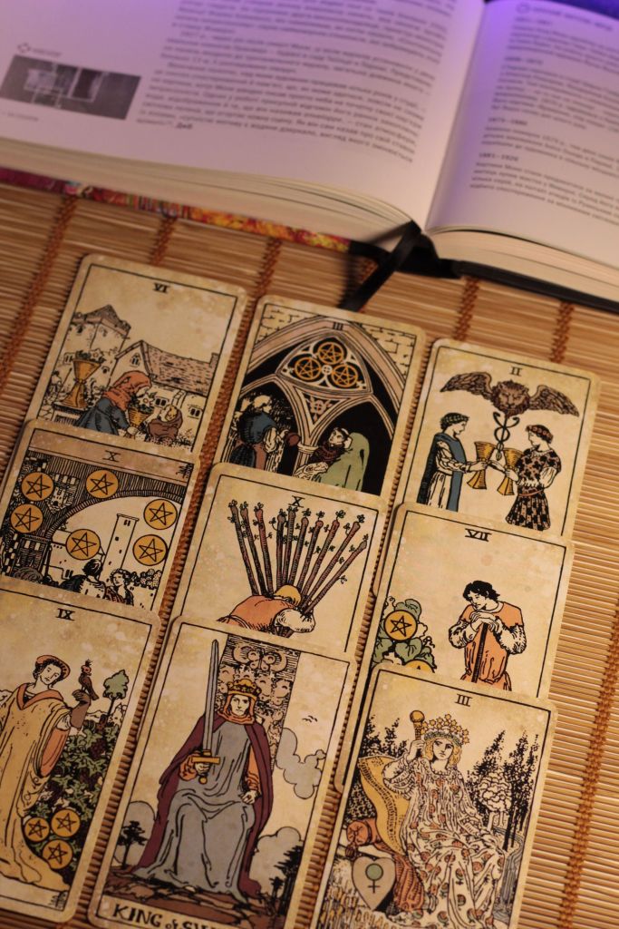 Tarotkarten neben einem aufgeschlagenen Buch